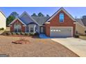 Charming home featuring a combination of brick and siding, a well-manicured lawn, and a welcoming entrance at 227 Lantana Dr, Locust Grove, GA 30248