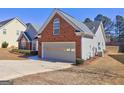 A spacious two-car garage with a driveway, set in a well-maintained exterior and manicured landscape at 227 Lantana Dr, Locust Grove, GA 30248