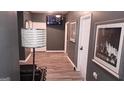 Hallway with dark gray walls, wood-look floors, and a mounted TV, decorated with artwork for a modern, inviting feel at 1528 Olympian Sw Way, Atlanta, GA 30310