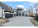 Beautiful white farmhouse exterior with a large driveway and well-manicured lawn at 4185 Etcetera Ln, Cumming, GA 30041