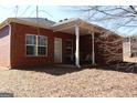 Brick home featuring a covered patio perfect for outdoor relaxation and entertaining in the backyard at 128 Astilbe Meadow Dr, Locust Grove, GA 30248