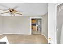 Living room showing neutral colored carpet, ceiling fan and view to kitchen at 6198 Rocky Creek Dr, Douglasville, GA 30135