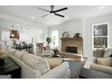 Bright and airy living room with a fireplace, ceiling fan, and open concept to the kitchen at 5167 Martin St, Covington, GA 30014