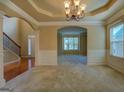 Spacious living room with elegant chandelier, wainscoting, and archway leading to another room at 1186 Diamond Xing, Mcdonough, GA 30252