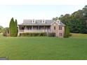 Charming brick home featuring a welcoming front porch and lush green lawn at 195 Twin Oaks Dr, Hampton, GA 30228