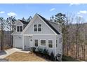 Two-story home showcasing light gray siding, a charming front entrance, and well-kept landscaping at 3175 Tackett Rd, Douglasville, GA 30135