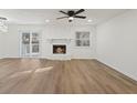 Spacious living room featuring a stone fireplace, modern ceiling fan, and wood flooring at 9317 Thomas Rd, Jonesboro, GA 30238