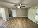 Open living room featuring wood-look floors, stairs to the second floor, and access to the back deck at 3859 Rosedale Ln, Douglasville, GA 30135