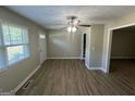 Bright living room with wood-look flooring, a ceiling fan, and lots of natural light from the window at 3859 Rosedale Ln, Douglasville, GA 30135