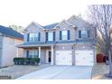 Charming two-story brick home with a well-manicured lawn, a two car garage, and classic shutters at 7625 Bowhead Ct, Fairburn, GA 30213