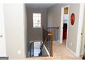 Carpeted staircase with a dark metal and wood railing leading to a hallway and view of the lower level at 7625 Bowhead Ct, Fairburn, GA 30213