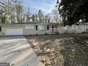 Single-story home featuring painted brick, an attached garage, and a wide concrete driveway at 2228 Headland Dr, East Point, GA 30344