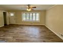 Bright living room featuring beautiful flooring, a ceiling fan, and a large bay window for natural light at 2228 Headland Dr, East Point, GA 30344