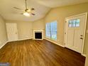 Bright living room with a vaulted ceiling, fireplace, wood-look flooring, and natural light from large windows at 890 Old Rocky Rd, Atlanta, GA 30349