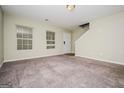 Spacious carpeted living room featuring a large window and staircase to the second floor at 415 Arthurs Ln, Covington, GA 30016
