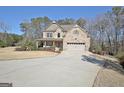 Traditional brick home with an attached garage and circular driveway offering ample parking at 115 Woodcanoe Ct, Peachtree City, GA 30269