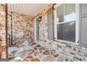 Covered front porch featuring stone veneer wall, flagstone floor, exterior light, and trimmed windows at 1685 Tabor Dr, Marietta, GA 30062