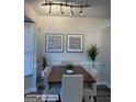 Cozy dining room featuring track lighting, modern art, neutral colors and seating for four at 8053 Woodlake Dr, Riverdale, GA 30274