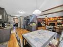 Spacious kitchen with gray cabinets, stainless appliances, tile countertops, and an adjacent dining area with hardwood flooring at 230 Mapledale Trl, Sharpsburg, GA 30277