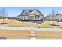 Charming home features a stone walkway, a well-manicured lawn, and inviting front porch at 132 Platinum Rdg, Sharpsburg, GA 30277