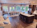 Open-concept living room with hardwood floors, large windows, modern furnishings, and a granite kitchen island at 870 Monroe Ne Dr, Atlanta, GA 30308