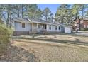 Inviting one-story home with brick accents and a manicured lawn surrounded by mature trees at 6187 Radford Dr, Riverdale, GA 30296