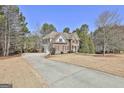 Stately brick home with a long driveway and expansive lawn, surrounded by trees at 44 Willow Leaf Way, Sharpsburg, GA 30277