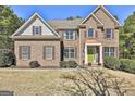 Stunning two-story brick house with a green front door, traditional shutters, and a well-maintained lawn at 44 Willow Leaf Way, Sharpsburg, GA 30277