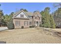 Spacious two-story brick home with a lush green lawn, framed by mature trees at 44 Willow Leaf Way, Sharpsburg, GA 30277