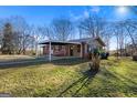 Cozy home with brick facade and attached carport, set in a natural landscape at 7427 Hollis Rd, Douglasville, GA 30135