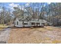 Quaint one-story home with black shutters, complemented by mature trees at 5211 Old Monticello Se St, Covington, GA 30014