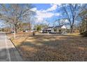 Traditional-style home showcasing a spacious front yard and a covered parking area at 5211 Old Monticello Se St, Covington, GA 30014