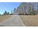 Spacious home with a long driveway winding through a lush, wooded landscape at 940 New Hope Rd, Fayetteville, GA 30214