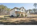 Two-story home with a covered front porch, dark shutters, and surrounded by a lush wooded landscape at 337 Paynes Lake Rd, Carrollton, GA 30116