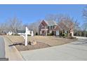 Beautiful brick home with lush landscaping, a circular driveway and a mailbox at 319 Corrigan Trce, Peachtree City, GA 30269