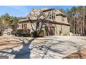 Side view of a well-maintained home featuring an attached garage and a long concrete driveway at 6 Water Oak Dr, Sharpsburg, GA 30277