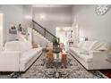 Bright living room with vaulted ceiling, staircase, neutral furniture, and decor at 6 Water Oak Dr, Sharpsburg, GA 30277