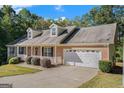 Beautiful single-story home with brick and a two-car garage, set amongst green trees at 225 Chinns Way, Hampton, GA 30228