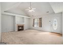 Bright living room featuring a fireplace, carpet, and a ceiling fan at 225 Chinns Way, Hampton, GA 30228
