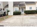 Exterior front view showing the parking area with a house featuring light siding and trimmed bushes at 6434 Wellington Chase Ct, Lithonia, GA 30058