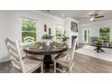 Inviting dining room featuring a stylish round table, natural lighting, and wood flooring at 10454 Trellis Lane (Lot 39), Hampton, GA 30228