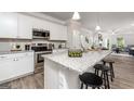 Bright kitchen with stainless steel appliances, granite countertops, and a breakfast bar with stool seating at 10454 Trellis Lane (Lot 39), Hampton, GA 30228