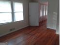 Bright bedroom featuring hardwood floors, window with blinds, with an open door to another room at 106 Flippen Rd, Stockbridge, GA 30281