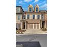 Beautiful brick townhome with a two car garage, manicured landscaping, and a walkway to the front door at 118 Via Roma, Woodstock, GA 30188