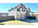 Side view of the home with a spacious two-car garage and well-kept lawn at 611 Winners Cir, Locust Grove, GA 30248