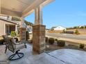 Inviting covered front porch with stone accents and comfortable seating, perfect for relaxing and enjoying the neighborhood views at 645 Timberbrook Dr, Sharpsburg, GA 30277