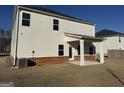 Rear view of a two-story home, featuring an installed AC unit and a covered patio area at 1224 Hibiscus Way, Mcdonough, GA 30253