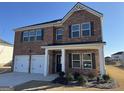 Charming two-story brick home featuring a two-car garage, dark shutters and a covered front porch at 1224 Hibiscus Way, Mcdonough, GA 30253