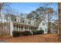 Inviting two-story home with a green roof and shutters, complemented by a well-manicured lawn and front porch at 495 N Oakland Cir, Mcdonough, GA 30253