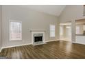 Spacious living room boasts gleaming hardwood floors, large windows, and a beautiful fireplace, offering a cozy ambiance at 495 N Oakland Cir, Mcdonough, GA 30253